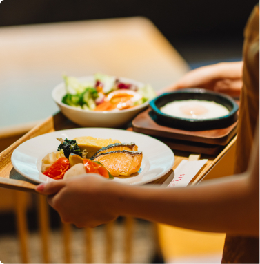 バイキングの朝食を取り分けてテーブルへ運んでいます。